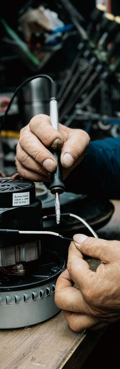 Electrician performing emergency electrical repair on industrial motor equipment