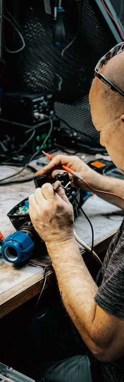 Technician using multimeter to test electronic components during project execution